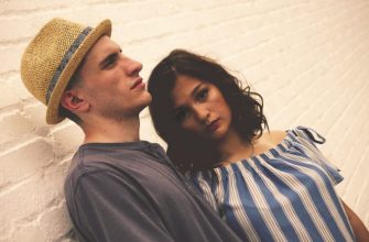 man and woman standing near brick wall